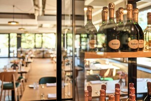 Garrafas de champanhe Ruinart numa estante num restaurante com vista para a sala de jantar.