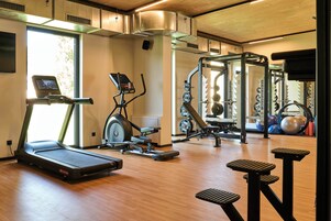 Ginásio com esteiras, elípticos e equipamentos de musculação.