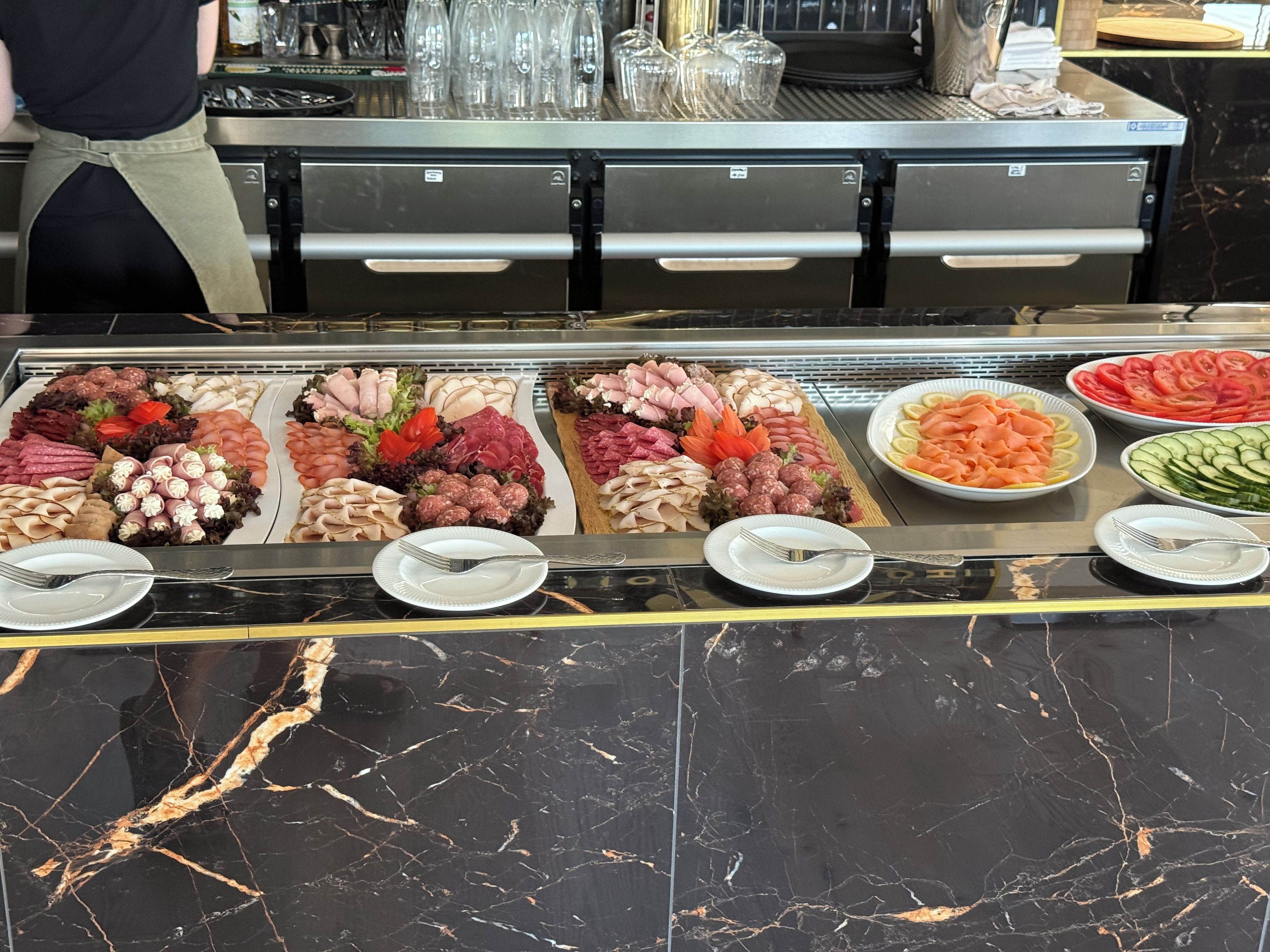 A buffet with various food items and utensils.