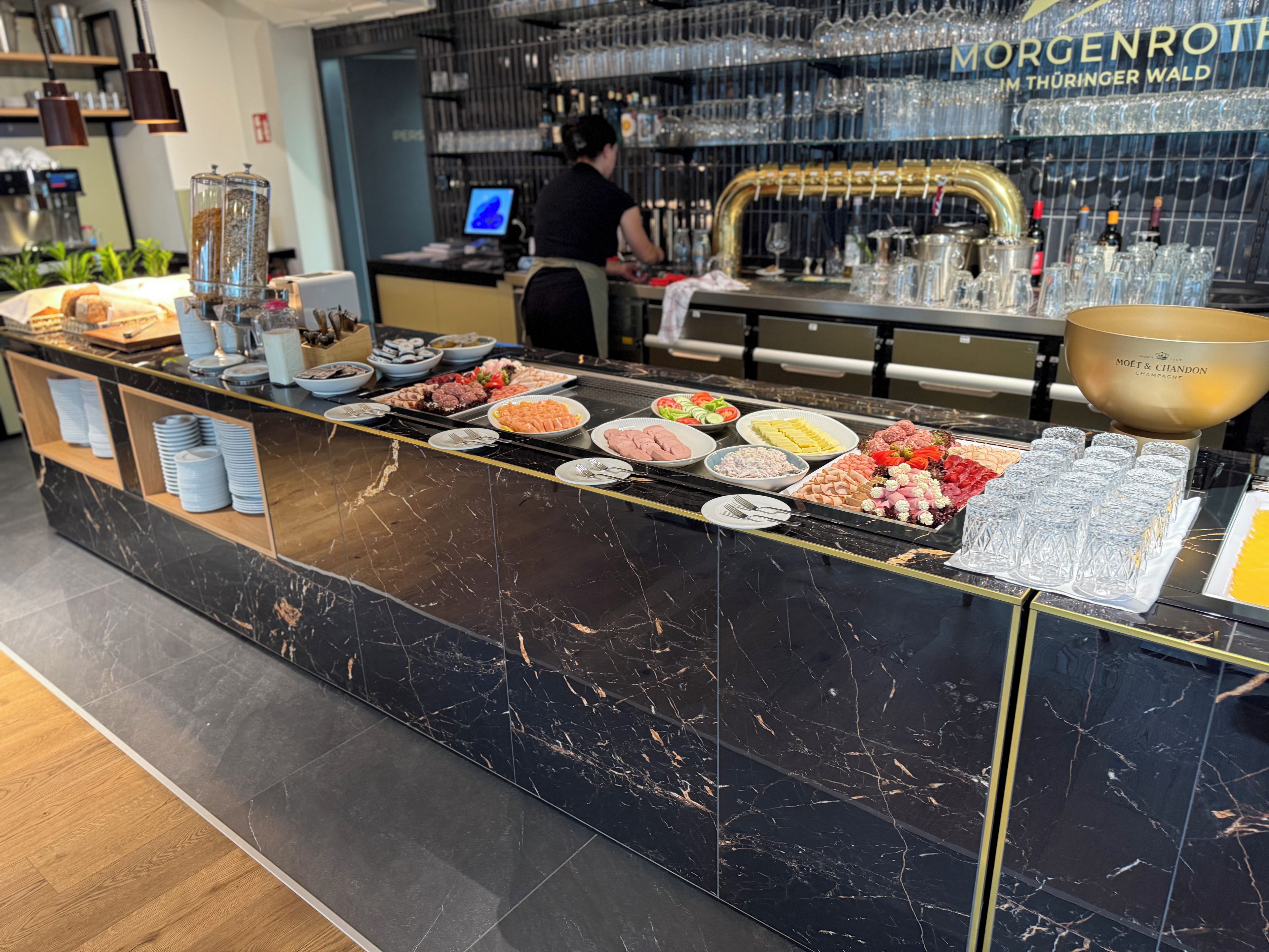 A buffet counter with various food items and a large bowl of champagne.