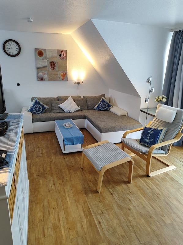 A modern living room with a sectional sofa, a wooden coffee table, a cushioned bench, and a floor lamp.