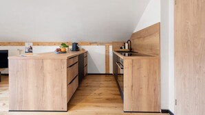 Une cuisine moderne avec des meubles en bois, un îlot central et un four encastré.