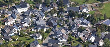 Vue aérienne d’un quartier résidentiel avec des maisons, des routes et des espaces verts.