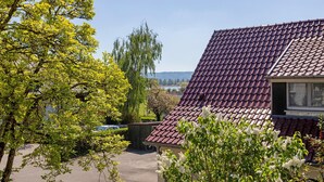 A residential building with a red-tiled roof, surrounded by greenery and a clear sky. - Casa Di Napolitano – Nature & Relaxation by Lake Constance (Radolfzell am Bodensee)