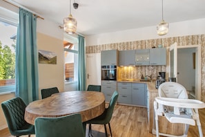 Une cuisine moderne avec une table à manger, des chaises et une chaise haute.