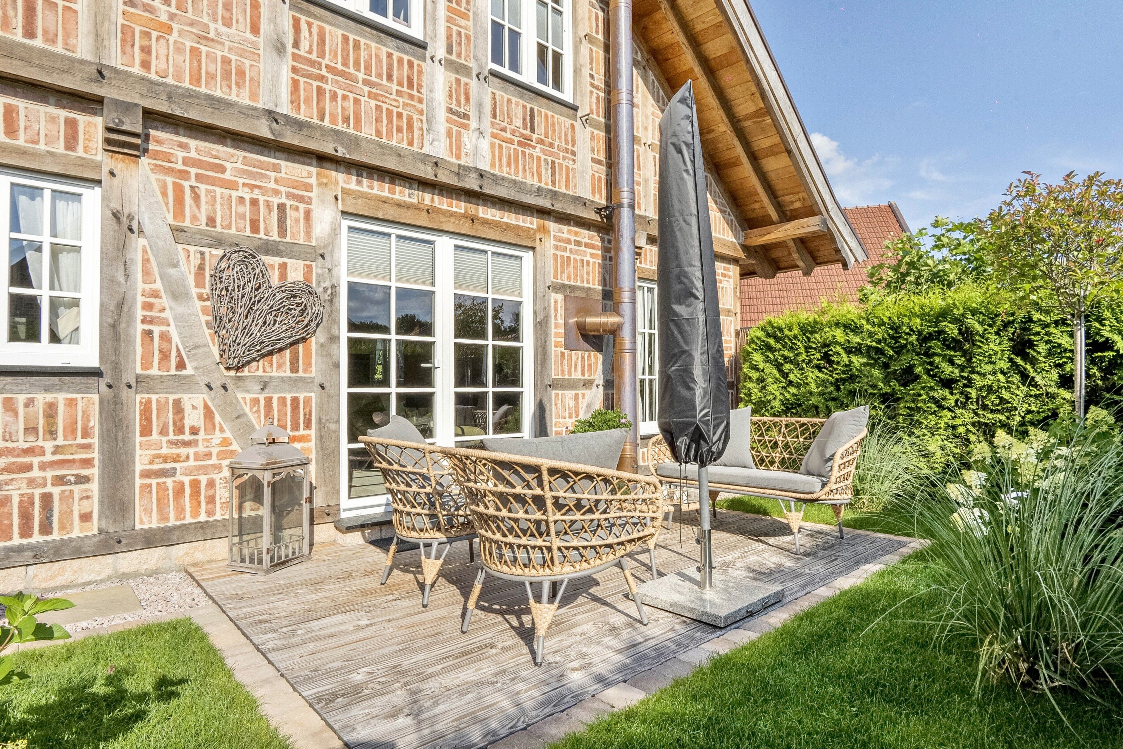 A patio with wicker furniture, a heart-shaped decoration, and a large umbrella.