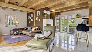 Ein geräumiges Wohnzimmer mit einem grünen Ledersessel, einem braunen Sofa und einem Couchtisch.