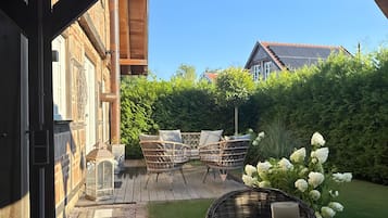 Eine Terrasse im Freien mit Korbmöbeln und einem Tisch mit Kerze.