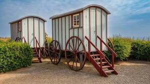 Zwei hölzerne Strukturen auf Rädern mit Treppen, vermutlich historisch oder dekorativ.