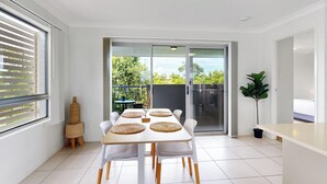 A modern kitchen with a dining area, large windows, and a view of greenery outside. - Cute & Cosy with Great Location (Moreton Bay City)