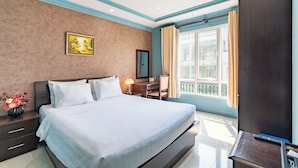 A modern hotel room with a large bed, a desk, a chair, and a TV. - La Bonita Hotel & Apartments (Ho Chi Minh City)
