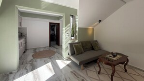 A modern living room with a marble floor, a grey sofa, and a wooden coffee table. - Heavens Balcony Meteora (Kalabaka)