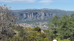 A mountainous landscape with a prominent rock formation in the background and a town in the foreground. - Heavens Balcony Meteora (Kalabaka)