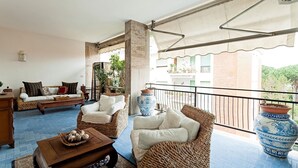 A cozy living room with wicker furniture, a coffee table, and a view of a balcony with potted plants. - Casa Azul in Sorrento center - My Rental Homes (Sorrento)