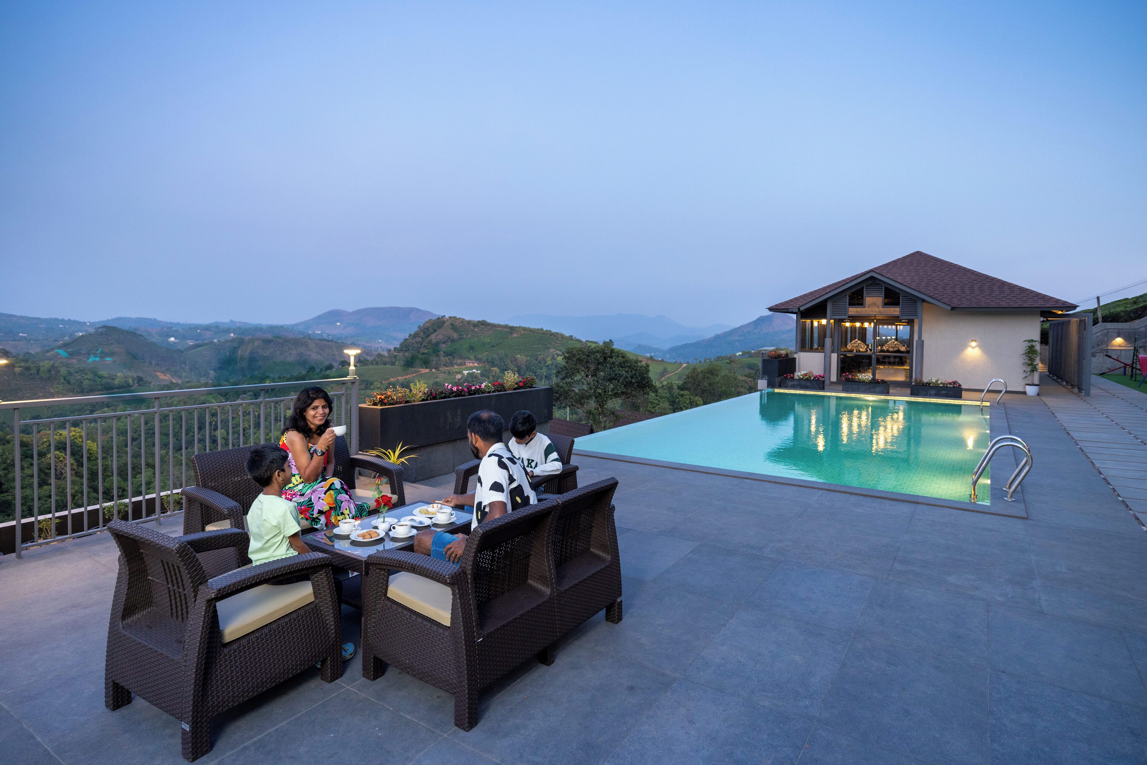 A dining area with wicker furniture and a poolside view.