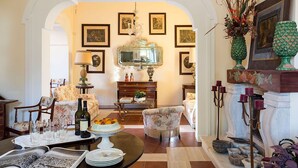 A traditional room with a fireplace, a dining table with a cake, and a chandelier. - Green Villa with heated pool - My Rental Homes (Salemi)
