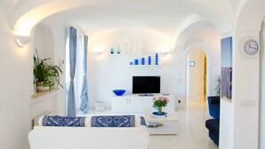 Un saló modern amb un sofà, televisió i elements decoratius.