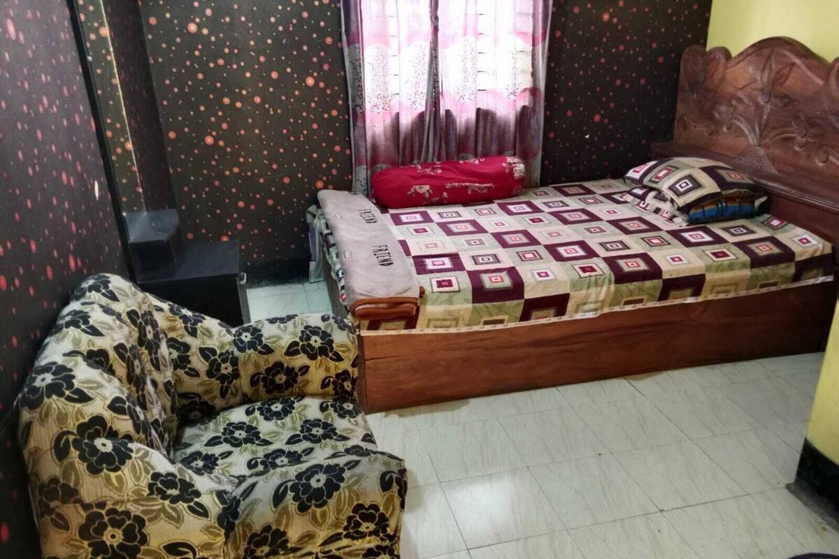 Une chambre à coucher avec un lit, un canapé et une table de chevet.