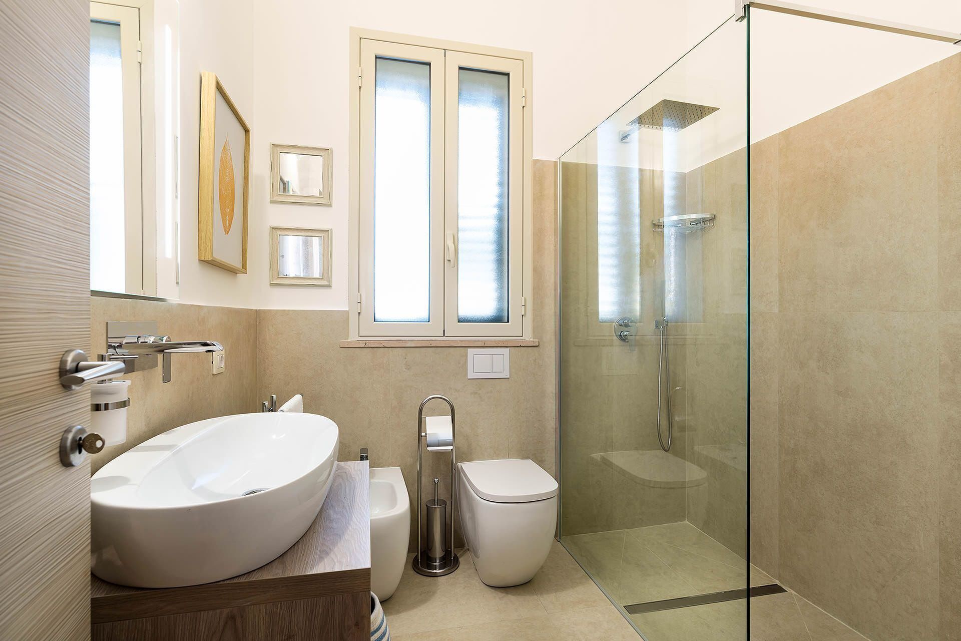 A modern bathroom with a freestanding bathtub, a toilet, and a glass-enclosed shower.