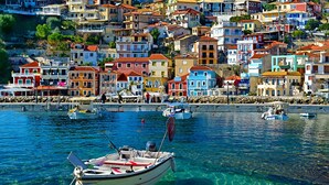 Une ville côtière aux bâtiments aux couleurs vives, où les bateaux sont amarrés dans le port.