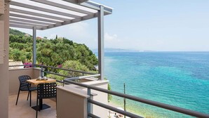 Un balcon avec vue sur la mer et sur une colline.