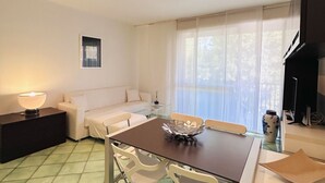 Una sala de estar moderna con una mesa de comedor, sofá y televisor.