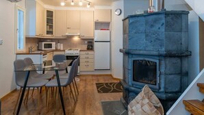 Una cucina compatta con un camino in pietra, un'area pranzo con sedie e un forno a microonde.