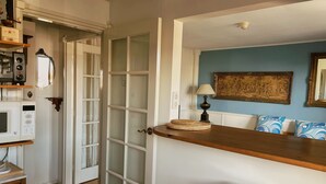 A kitchen with a microwave, a refrigerator, and a wooden countertop.