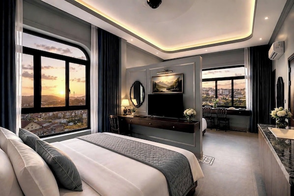 Una habitación de hotel moderna con una cama grande, un escritorio, un televisor y vistas a un paisaje urbano.