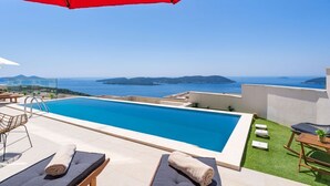 A rooftop pool with a clear view of the sea and islands.