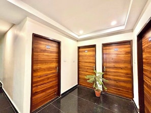Un pasillo con tres puertas de madera, cada una marcada con un número.
