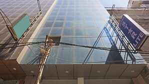 A modern building with a glass facade and a sign indicating it is a hotel. - HOTEL STAR LITE (New Delhi)