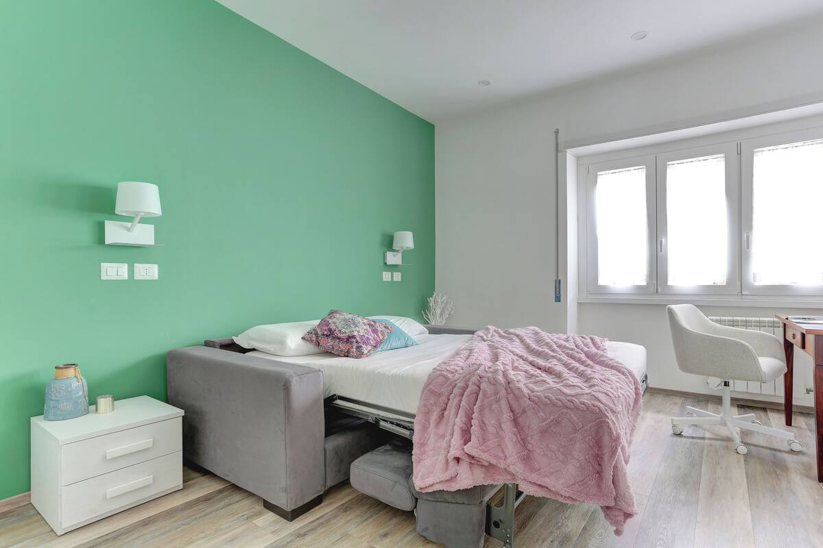 Ein Schlafzimmer mit einem Bett, Nachttischen, einem Schreibtisch und einem Stuhl.