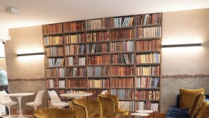 Een leeshoek in een bibliotheek met boekenplanken, comfortabele zitplaatsen en kleine tafels.
