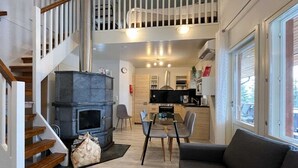 Ein modernes Interieur mit Treppe, Kamin, Essbereich und Küche.