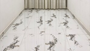A room with a ceiling fan, a curtain, and patterned floor tiles. - Ramalayam (Faizabad)