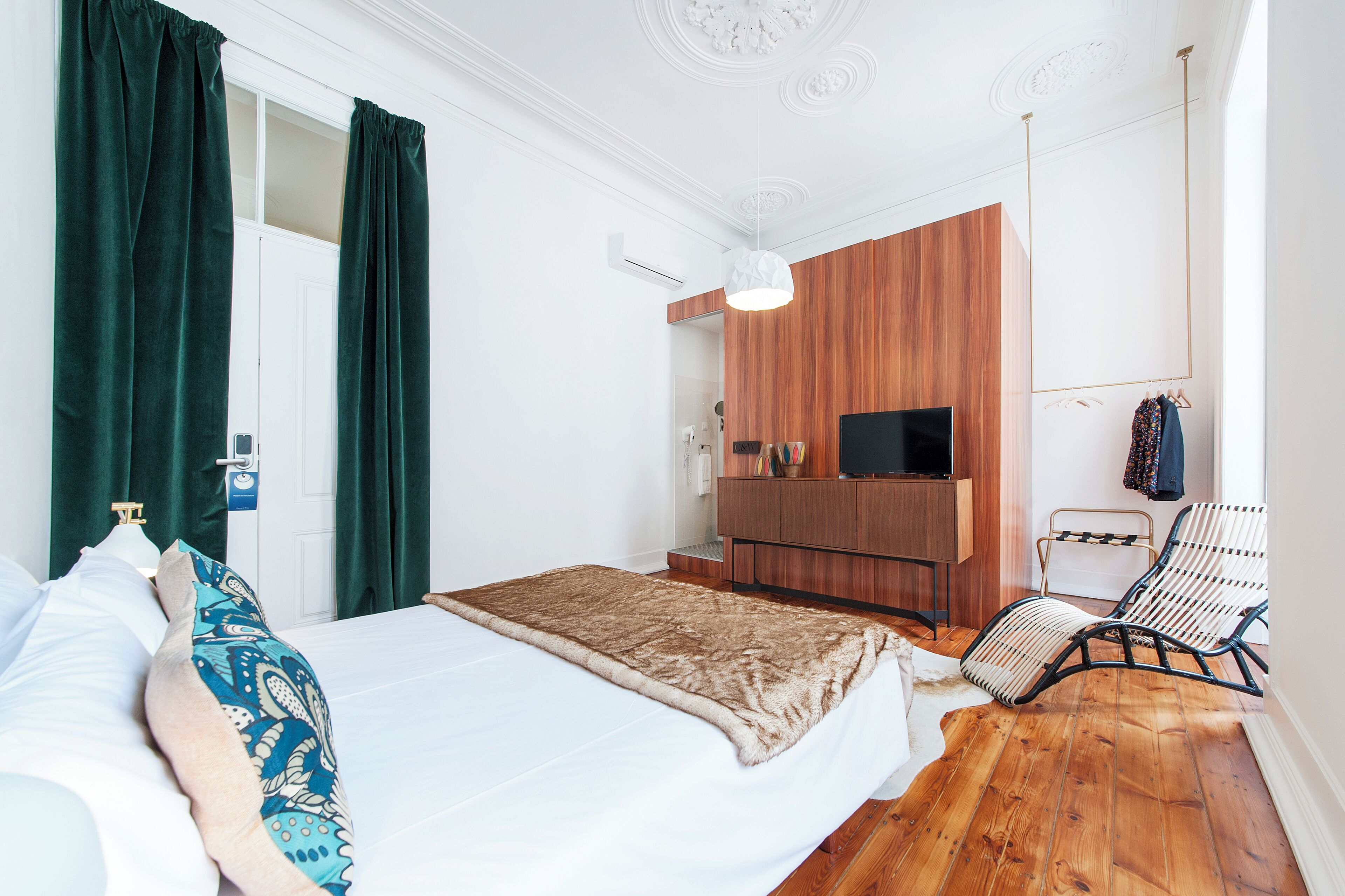 Une chambre à coucher avec un lit, une armoire en bois, une télévision et une chaise.