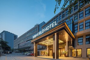 Un hotel moderno con una entrada destacada, ventanas amplias y una fachada bien iluminada.