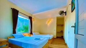 A room with two wooden beds, a desk, and a window with curtains. - Ha Lan Homestay (Ninh Binh)
