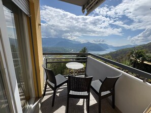 A balcony with a table and chairs, overlooking a mountainous landscape. - Al Ponte Hotel (Cademario)