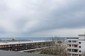 A multi-story building with a flat roof, a small structure on the roof, and a view of the sea. - GuestHost - Comfortable Apartment with Sea View (Lido delle Nazioni)