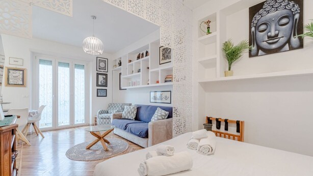 Une chambre d’hôtel moderne équipée d’un lit, d’un canapé, d’une table à manger et d’une grande fenêtre.
