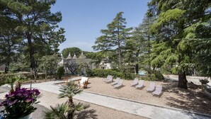 A garden with a pool, lounge chairs, and a gazebo. - GuestHost Borgo Lucia with pool - Trullo Catenella (Selva di Fasano)