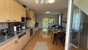Una cocina moderna con armarios de madera, microondas integrado y cafetera.