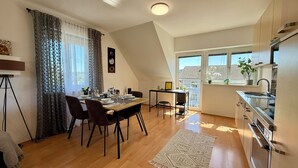 Una cocina moderna con comedor, piso de madera y vistas al exterior.