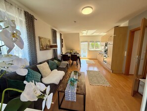 Un menjador modern amb sofà, zona de menjador i cuina.