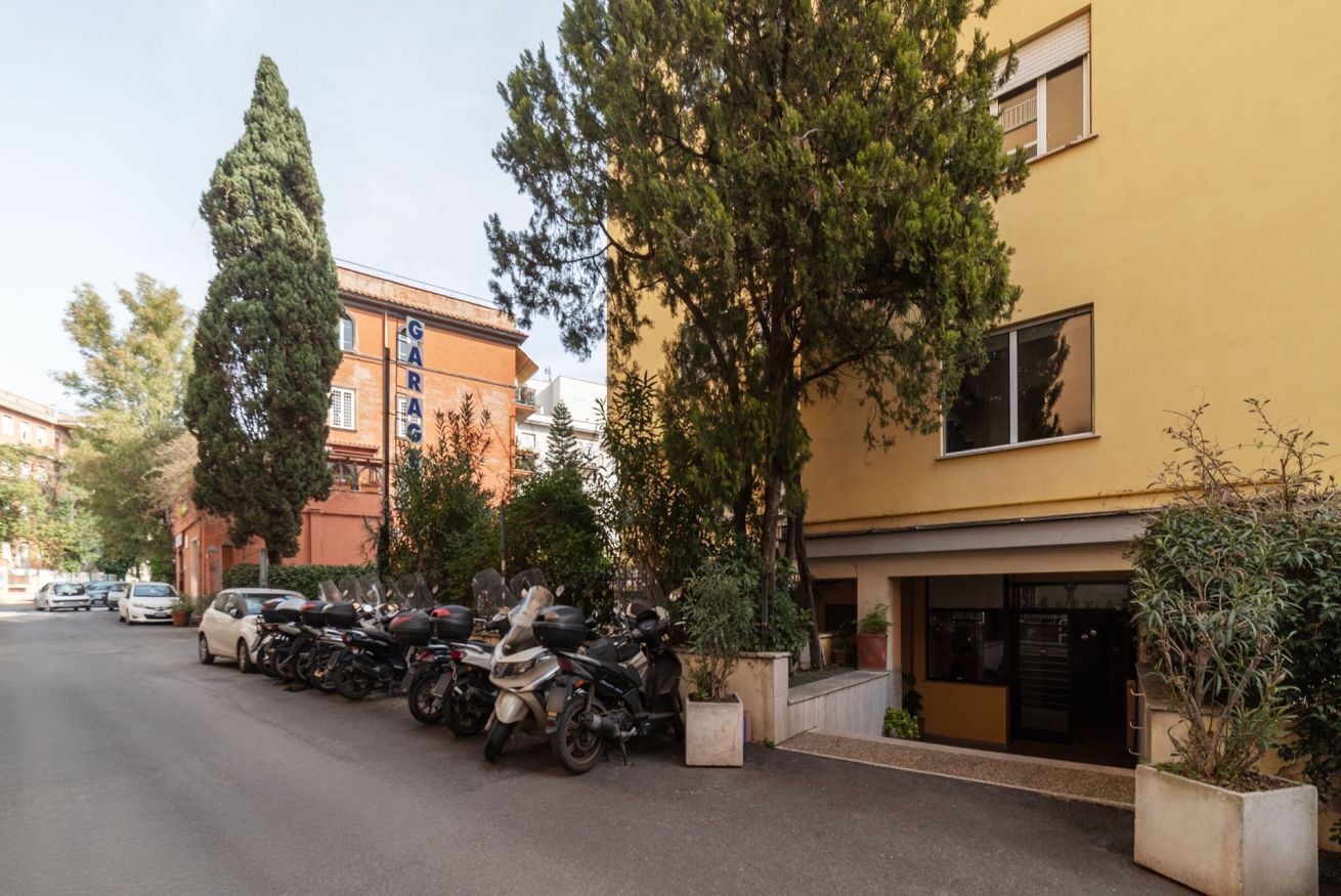 Eine Straße mit abgestellten Motorrädern und einem Gebäude mit Schilder für eine Garage.