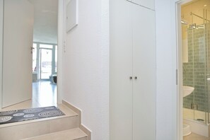 A modern bathroom with a glass shower, a white sink, and a beige-tiled floor. - House Belvedere App. 5 (Grömitz)