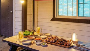 Una mesa de comedor con diversos platos, una jarra de cerveza y una vela.