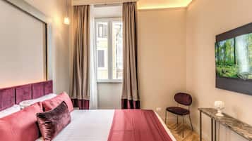 Ein Hotelzimmer mit Bett, Sessel, kleinem Tisch und einem Bild an der Wand.
